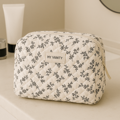 Vanity case souple pour femme blanc à motifs posé sur une table